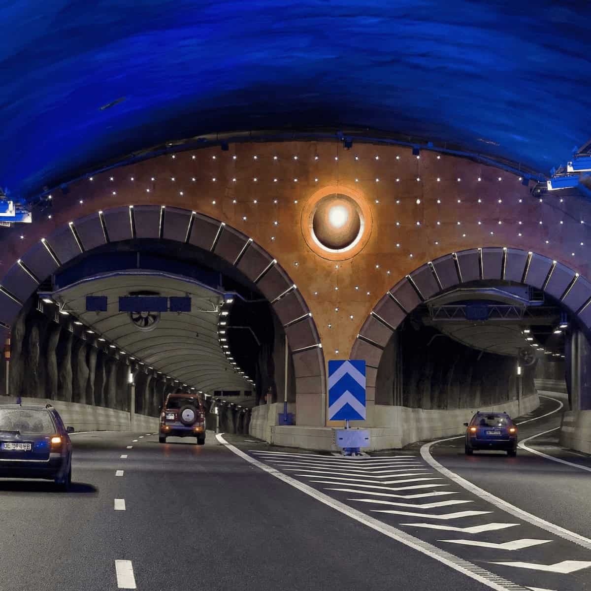 Puente en túnel con iluminación moderna y tráfico en movimiento, en un entorno urbano, con luces y v.